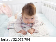 Двухмесячный малыш пытается держать головку, лежа на валике из полотенца. Стоковое фото, фотограф Кекяляйнен Андрей / Фотобанк Лори