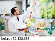 Pharmacist writing down assortment of drugs. Стоковое фото, фотограф Яков Филимонов / Фотобанк Лори