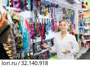 Female shop assistant showing leashes for pets. Стоковое фото, фотограф Яков Филимонов / Фотобанк Лори