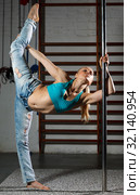 Woman practicing pole dancing in dark studio. Стоковое фото, фотограф Яков Филимонов / Фотобанк Лори