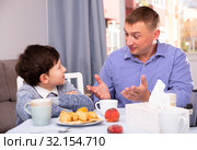 Upset father and offended son arguing in domestic interior. Стоковое фото, фотограф Яков Филимонов / Фотобанк Лори
