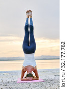 Woman doing Hatha yoga headstand or Sirsasana on nature rear view. Стоковое фото, фотограф Alexander Tihonovs / Фотобанк Лори