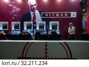 Молодые люди играют в компьютерную игру Hitman 2 на выставке "Игромир" в выставочном комплексе "Крокус Экспо" города Москвы, Россия (2018 год). Редакционное фото, фотограф Николай Винокуров / Фотобанк Лори