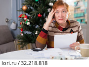 Senior woman engaged in home accounting in the new year holiday. Стоковое фото, фотограф Яков Филимонов / Фотобанк Лори