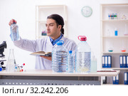 Young male chemist experimenting in lab. Стоковое фото, фотограф Elnur / Фотобанк Лори