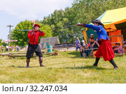 Russia, Samara, June 2016: A battle of musketeers on swords for the audience of the festival "Journey to the Past", which takes place near Samara on a sunny summer day. Редакционное фото, фотограф Акиньшин Владимир / Фотобанк Лори
