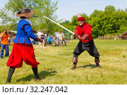 Russia, Samara, June 2016: A battle of musketeers on swords for the audience of the festival "Journey to the Past", which takes place near Samara on a sunny summer day. Редакционное фото, фотограф Акиньшин Владимир / Фотобанк Лори