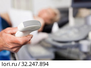 Male doctor holding ultrasonic probe in hand, ultrasound machine and patient ready for diagnostic. Стоковое фото, фотограф Яков Филимонов / Фотобанк Лори