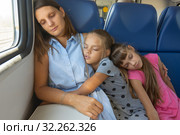 Мама и две дочки уснули в вагоне электропоезда. Стоковое фото, фотограф Иванов Алексей / Фотобанк Лори