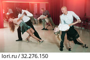 Adult pairs dancing tango movements in modern dance studio. Стоковое фото, фотограф Яков Филимонов / Фотобанк Лори