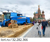 Туристы гуляют рядом с зерноуборочным комбайном «Агромаш 3000» среди пшеничных колосьев на Красной площади. Московский фестиваль «Золотая осень». Москва, Россия (2019 год). Редакционное фото, фотограф Овчинникова Ирина / Фотобанк Лори