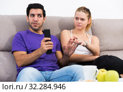 Couple on sofa quarreling because of TV remote. Стоковое фото, фотограф Яков Филимонов / Фотобанк Лори