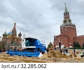 Зерноуборочный комбайн «Агромаш 3000» среди пшеничных колосьев на фоне Спасской башни Кремля. Московский фестиваль «Золотая осень». Москва, Россия (2019 год). Редакционное фото, фотограф Овчинникова Ирина / Фотобанк Лори