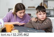 Upset boy and angry mother having quarrel during breakfast at home. Стоковое фото, фотограф Яков Филимонов / Фотобанк Лори