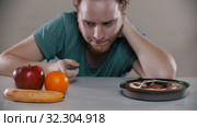 Man cannot choose between fruits and cake. Стоковое видео, видеограф Константин Шишкин / Фотобанк Лори