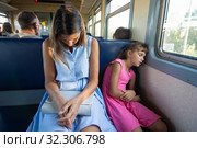 Уставшие мама и дочка крепко спят в электропоезде. Стоковое фото, фотограф Иванов Алексей / Фотобанк Лори