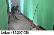 A young woman in blue jeans and a cage shirt swings and washes the floor on a staircase next to an elevator in a Stalinist-built apartment building, Cleaning public spaces by a labor immigrant cleane. Стоковое видео, видеограф Куликов Константин / Фотобанк Лори
