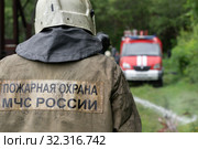 Firefighters of Fire Department of Federal Fire Service, back view with emblem Emercom of Russia on uniform rescuers of Ministry of Civil Defence, Emergencies and Disaster Relief of the Russian Federation (MChS) (2019 год). Редакционное фото, фотограф А. А. Пирагис / Фотобанк Лори