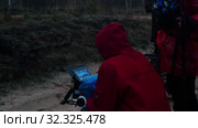 A man in red jacket holding a camera and filming cinema scene in the forest. Стоковое видео, видеограф Константин Шишкин / Фотобанк Лори