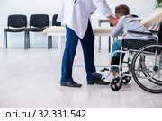 Young male doctor pediatrist and boy in wheel-chair. Стоковое фото, фотограф Elnur / Фотобанк Лори