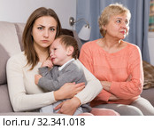 Adult female with her mother are having disagreements for parenting child. Стоковое фото, фотограф Яков Филимонов / Фотобанк Лори