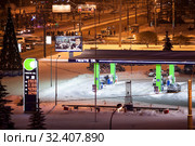 The Neste petrol station is on the Constitution Square at night time and winter season. Санкт-Петербург (2012 год). Редакционное фото, фотограф Кекяляйнен Андрей / Фотобанк Лори