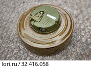 Khaki colour modern anti-tank mine lies on concrete surface. Стоковое фото, фотограф Олег Белов / Фотобанк Лори