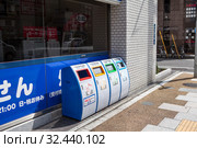 Four recycling bins are on street of city. Trash containers with icons of cans, glass bottles, plastic bottles, plastics and papers. (2013 год). Редакционное фото, фотограф Кекяляйнен Андрей / Фотобанк Лори