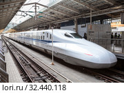 JR West N700 series train stands on Tokyo station on the Tokaido Shinkansen line. It is Nozomi bullet train which stop at only the largest stations. Consists from 16 cars. Токио, Япония (2013 год). Редакционное фото, фотограф Кекяляйнен Андрей / Фотобанк Лори