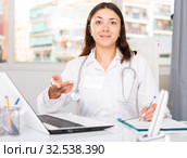 Practicioner girl in medical uniform is working with documents and laptop. Стоковое фото, фотограф Яков Филимонов / Фотобанк Лори