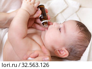 A doctor gives newborn baby vitamin D3. Child immunization with drop in clinic. Стоковое фото, фотограф Кекяляйнен Андрей / Фотобанк Лори