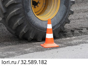 Wheel with tire on road reclaimer during roadworks, traffic road cone on asphalt (2019 год). Редакционное фото, фотограф А. А. Пирагис / Фотобанк Лори
