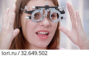 Ophthalmology treatment - a young smiling woman putting on a device for vision test. Стоковое видео, видеограф Константин Шишкин / Фотобанк Лори