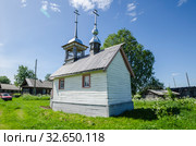 Красивая деревянная церковь со шпилем среди зеленого луга. Часовня Воздвижения Креста Господня в деревне Слобода. Россия, Архангельская область, Каргополье (2014 год). Стоковое фото, фотограф Яковлев Сергей / Фотобанк Лори