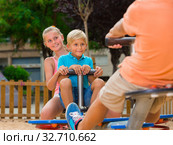 Company of kids are teetering on the swing. Стоковое фото, фотограф Яков Филимонов / Фотобанк Лори