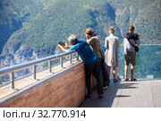 People photographing on spectacular Stegastein viewing platform above Aurlandsfjord. It is located on national tourist route Aurlandsfjellet. Norway (2018 год). Редакционное фото, фотограф Кекяляйнен Андрей / Фотобанк Лори