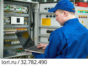 Electrician works with tester in switchbox. Стоковое фото, фотограф Дмитрий Калиновский / Фотобанк Лори