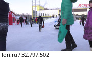 Дети катаются с ледяной горки на городской площади. Children ride on an ice slide in the town square. (2019 год). Редакционное видео, видеограф Евгений Романов / Фотобанк Лори