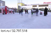 Дети катаются с ледяной горки на городской площади. Children ride on an ice slide in the town square. (2019 год). Редакционное видео, видеограф Евгений Романов / Фотобанк Лори