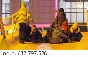 Дети катаются с ледяной горки на городской площади. Children ride on an ice slide in the town square. (2019 год). Редакционное видео, видеограф Евгений Романов / Фотобанк Лори