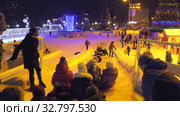 Дети катаются с ледяной горки на городской площади. Children ride on an ice slide in the town square. (2019 год). Редакционное видео, видеограф Евгений Романов / Фотобанк Лори