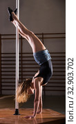 Young woman in denim shorts practicing pole dancing. Стоковое фото, фотограф Яков Филимонов / Фотобанк Лори