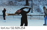 A young blonde woman figure skater spinning around herself on ice rink outdoors. Стоковое видео, видеограф Константин Шишкин / Фотобанк Лори