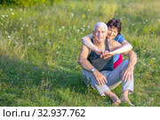 Mature beautiful couple in love on a green lawn in a park on a summer sunny day. Стоковое фото, фотограф Акиньшин Владимир / Фотобанк Лори