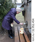 Пожилая женщина набирает святую воду (2020 год). Редакционное фото, фотограф EgleKa / Фотобанк Лори