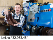 Cheerful male worker showing fixed shoes. Стоковое фото, фотограф Яков Филимонов / Фотобанк Лори