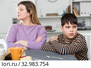 Upset mother and unhappy son sitting after quarrel indoors. Стоковое фото, фотограф Яков Филимонов / Фотобанк Лори