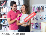 woman and man bayers choosing long rubber phallus in the sex shop. Стоковое фото, фотограф Яков Филимонов / Фотобанк Лори