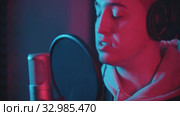 A man in headphones rapping through the pop-filter in the microphone. Стоковое видео, видеограф Константин Шишкин / Фотобанк Лори