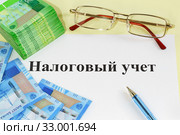 Очки, деньги, ручка и надпись "Налоговый учет" Стоковое фото, фотограф Наталья Гармашева / Фотобанк Лори